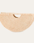 A beige, geometric, shell-shaped hand tote bag made from woven raffia.