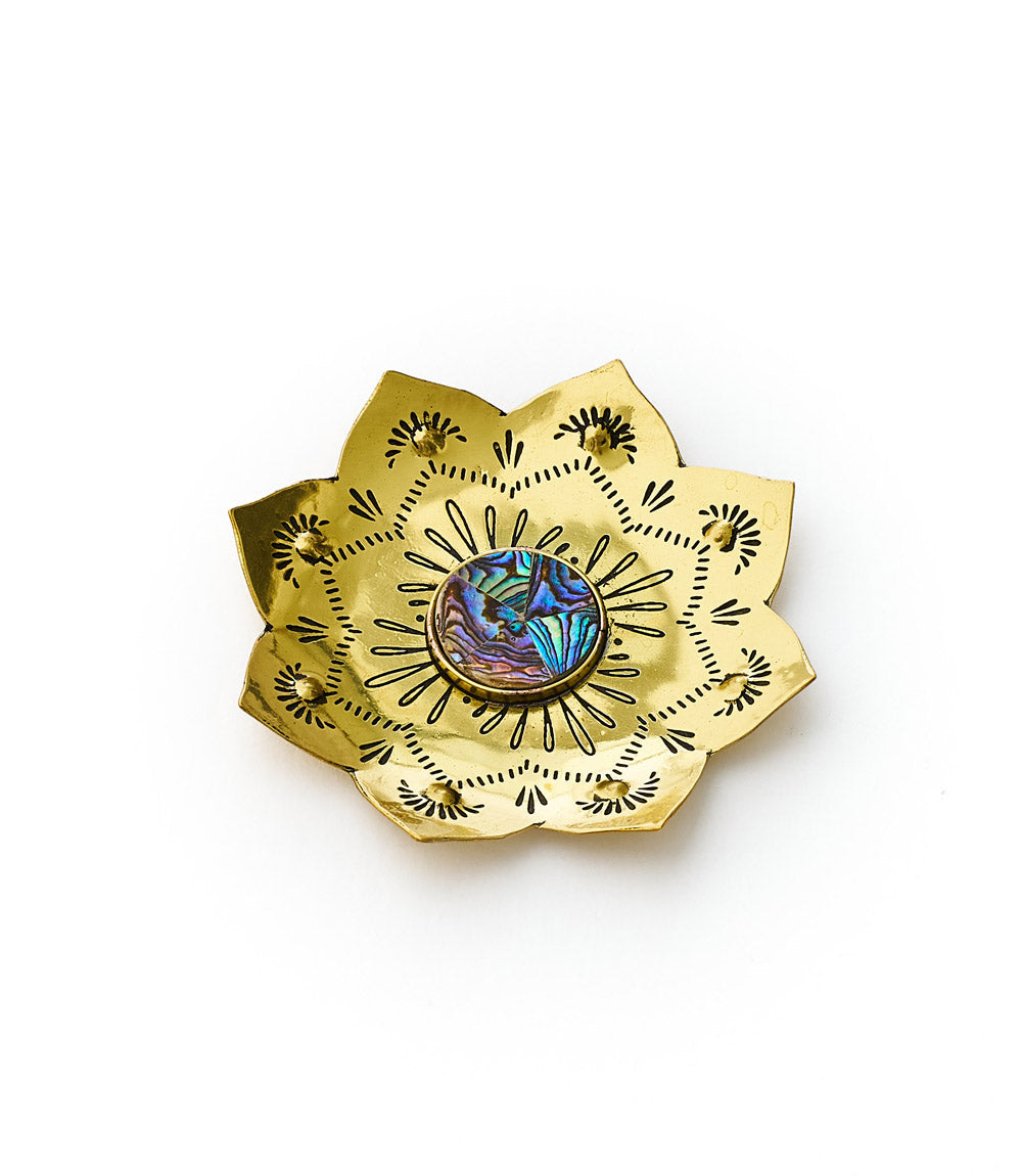 A brass tray with a lotus design and an inlaid abalone center, giving it a shimmering appearance