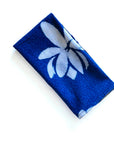 Blue fabric with white floral lotus design on a white background