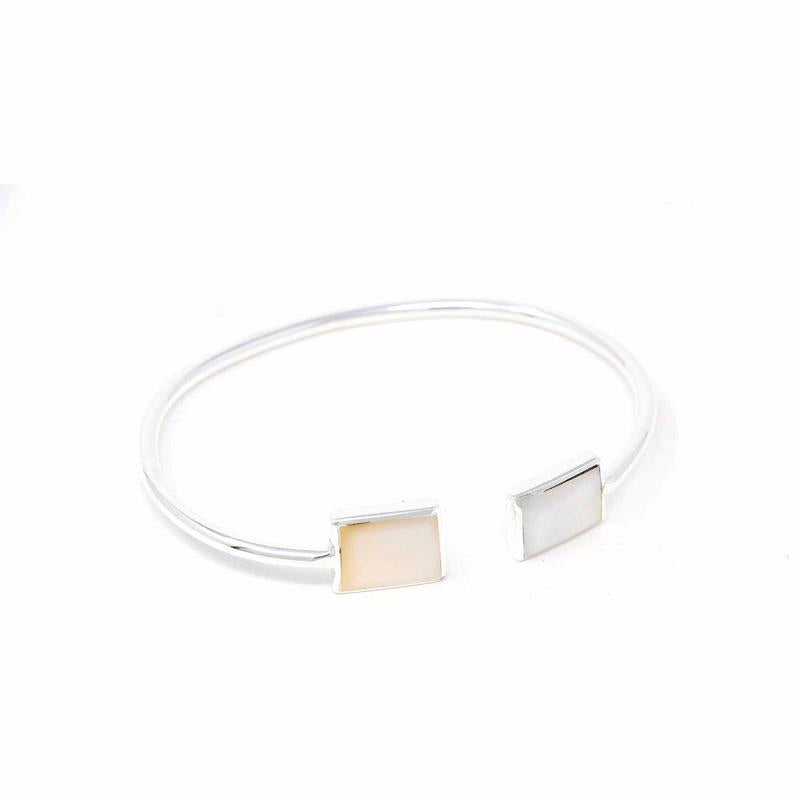 A silver-plated cuff bracelet with square caps embedded with Mother of Pearl, displayed against a white background.
