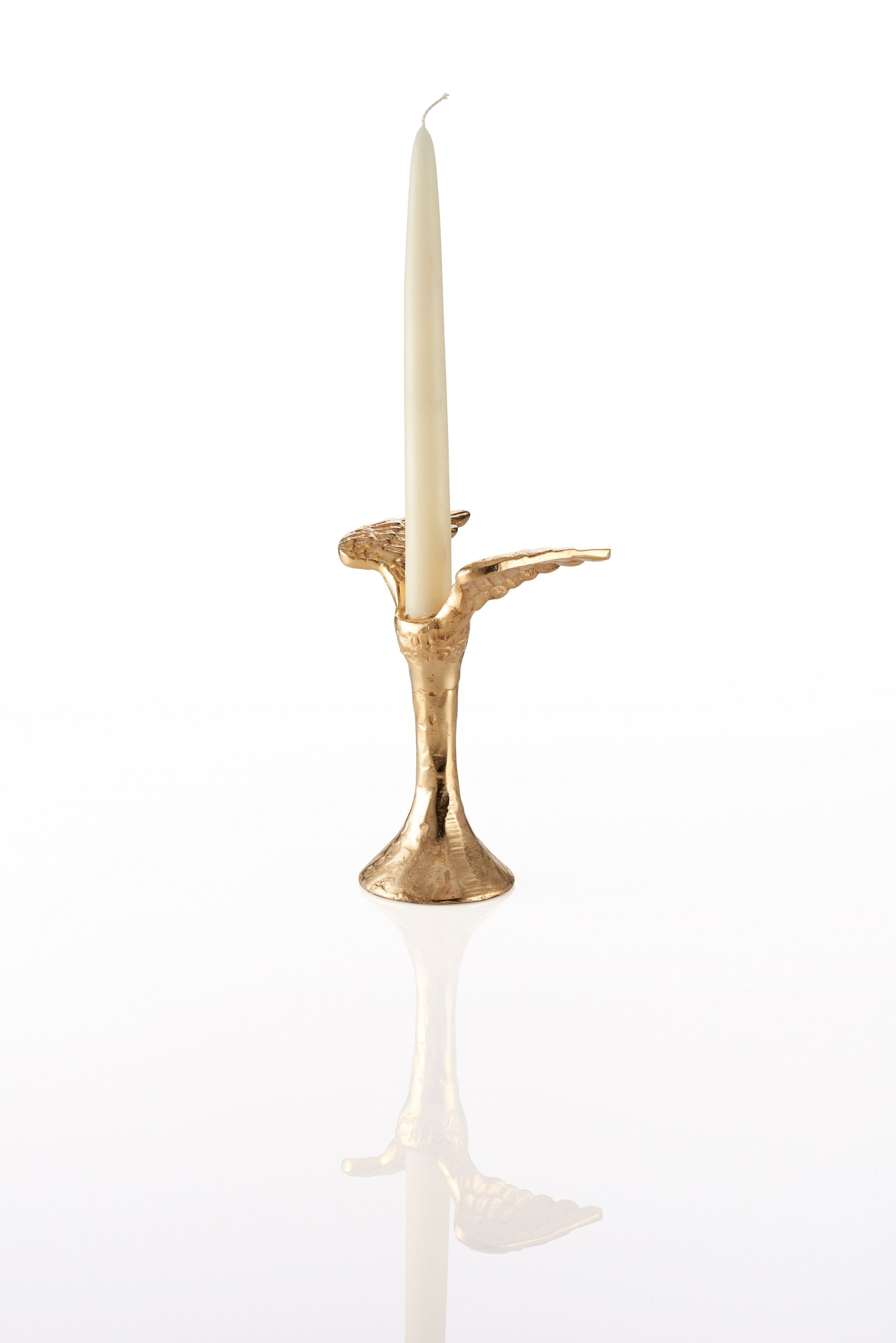 Gold candle holder designed with angel wings with a white candle on a white background