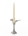 Silver candle holder with a white candle on a white background