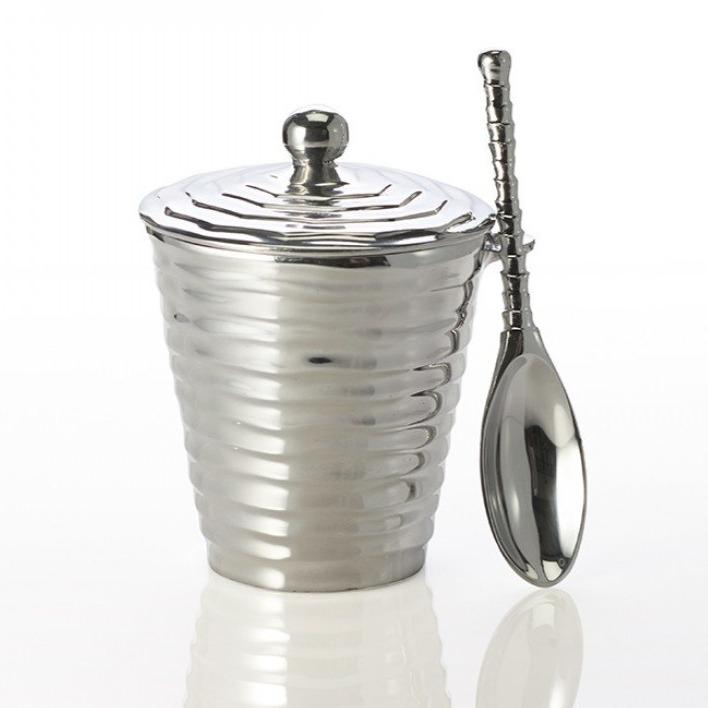 Silver textured jar with lid and spoon on a white background