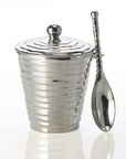 Silver textured jar with lid and spoon on a white background