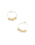 One inch gold plated wire hoops with a hook and loop closure hold 3 white crystal flowers with gold bead centers displayed on a white background.