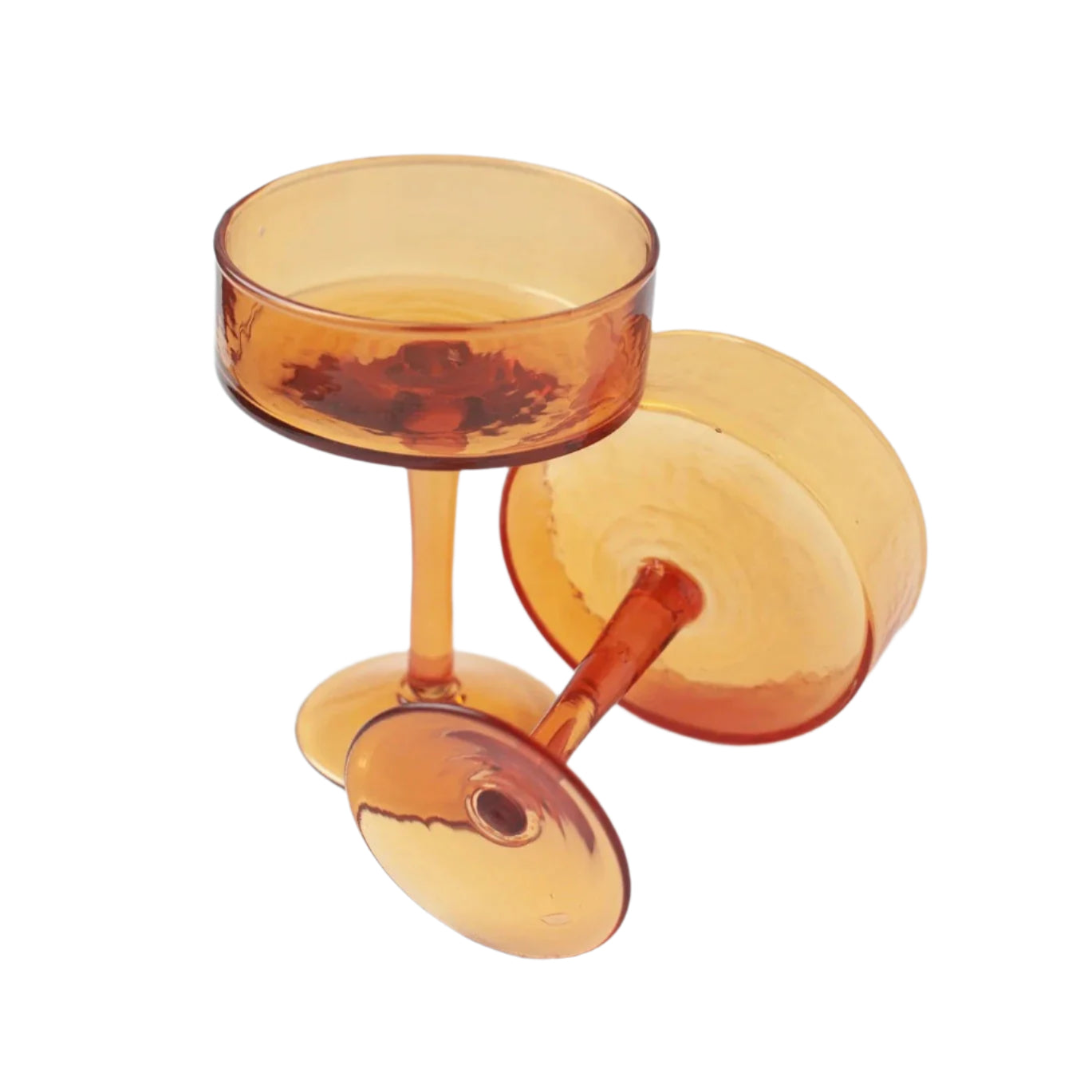 A set of four handblown hammered amber-colored cocktail glasses, including a cup and a saucer, made from recycled glass