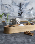 Wooden herb and spice holder on a table with glasses and herbs in the background