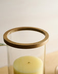 Glass candle holder with wooden top on a light background
