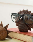 Wooden animal-shaped glasses holders on books with a blurred background