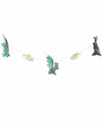 A hand-crafted felt garland featuring multicolored dragon shapes and pom poms strung along a thread