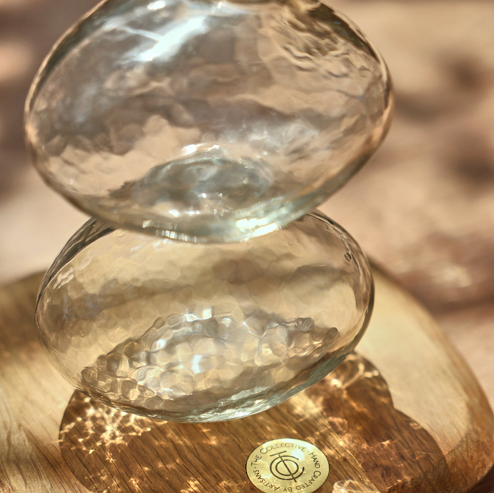 Two glass bowls stacked on a wooden surface with a blurred background
