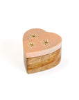 A heart-shaped pink marble keepsake box with brass stars inlay on the lid, set on a wooden base.