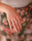 A hand wearing a ring made from .925 sterling silver and semi-precious moonstone.