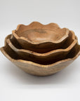 Set of three wooden bowls of different sizes on a white background
