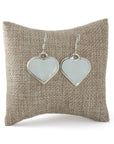 Sterling silver Mother-of-Pearl shell earrings made with gemstone displayed on a pillow