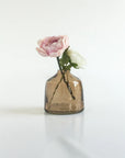 Smoked glass vase with a pink flower on a white background
