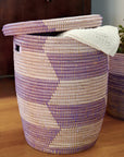 Woven laundry basket with a lid on a wooden surface