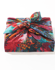 Colorful floral gift wrap with a knot on a white background