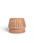 Ceramic pot with striped design on a white background