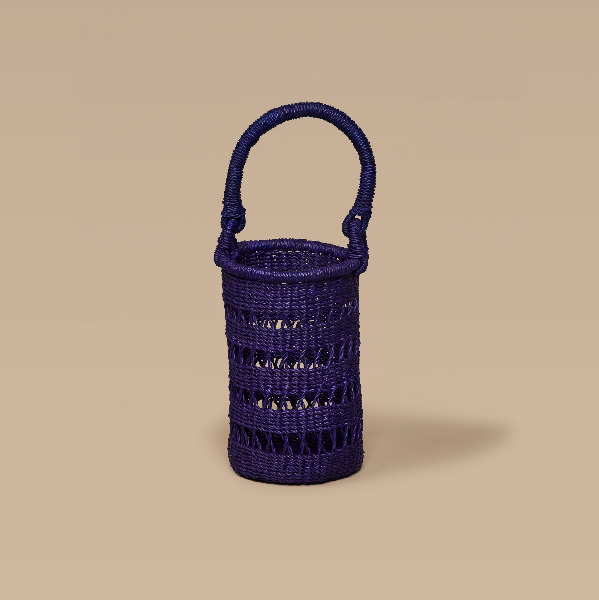 An Iridescent wine tote made from elephant grass, featuring an open weave design and a handle for carrying.
