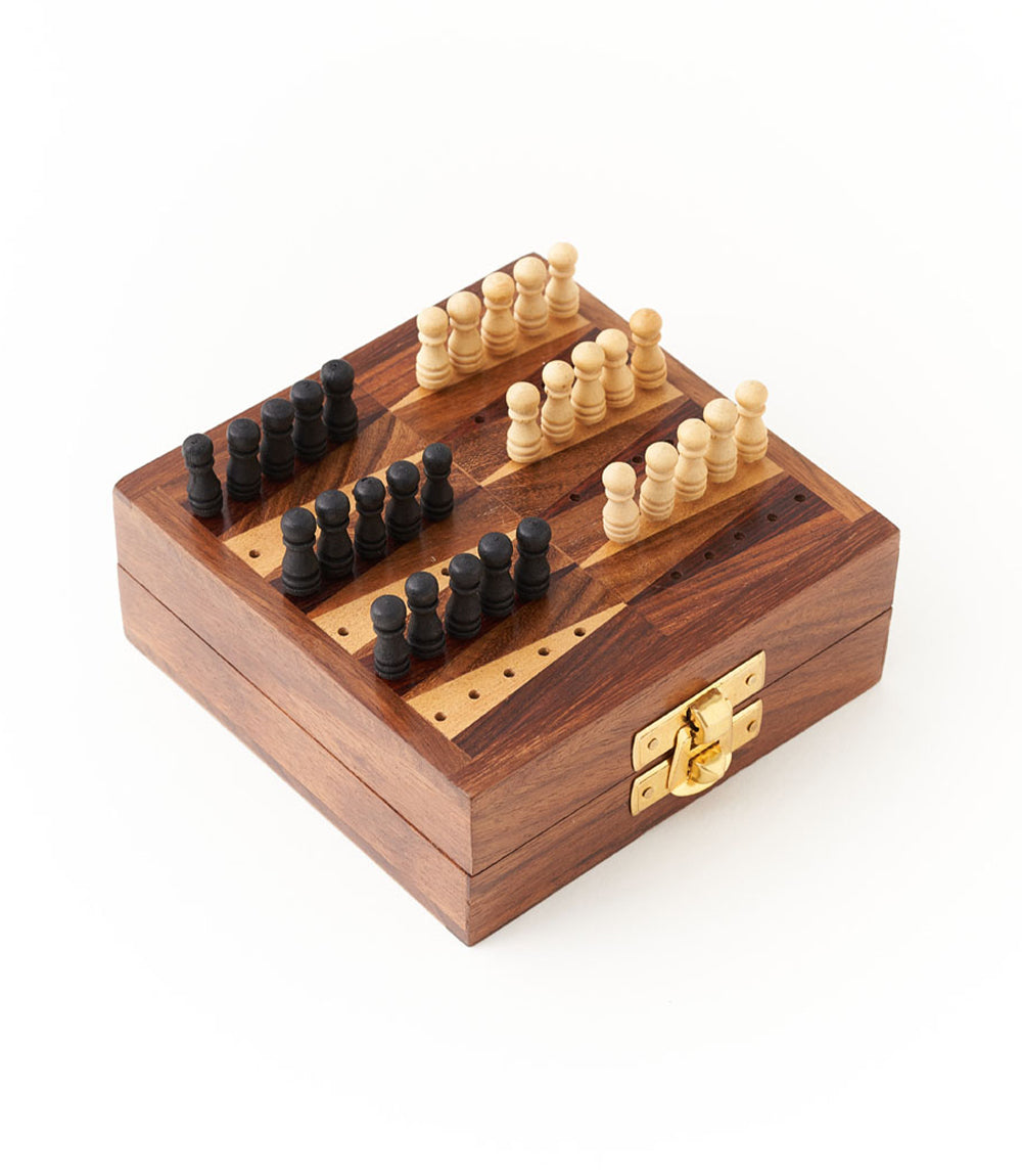 A wooden backgammon game set with black and white pegs arranged on the board with a white background.