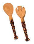 A pair of hand-carved wooden salad servers with giraffe patterns on the handles