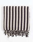 A black and white striped Turkish bath towel with fringes on the ends.