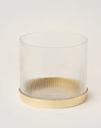 A clear glass vase with fluted sides and a ribbed edge, featuring a gold-colored rim and base.