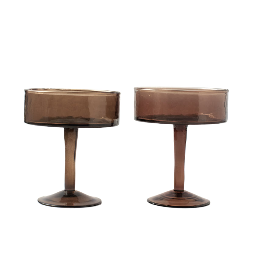 A set of two handblown hammered cocktail glasses with a smoke color finish on a white background