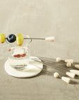Glass of water with fruit skewer on a concrete surface
