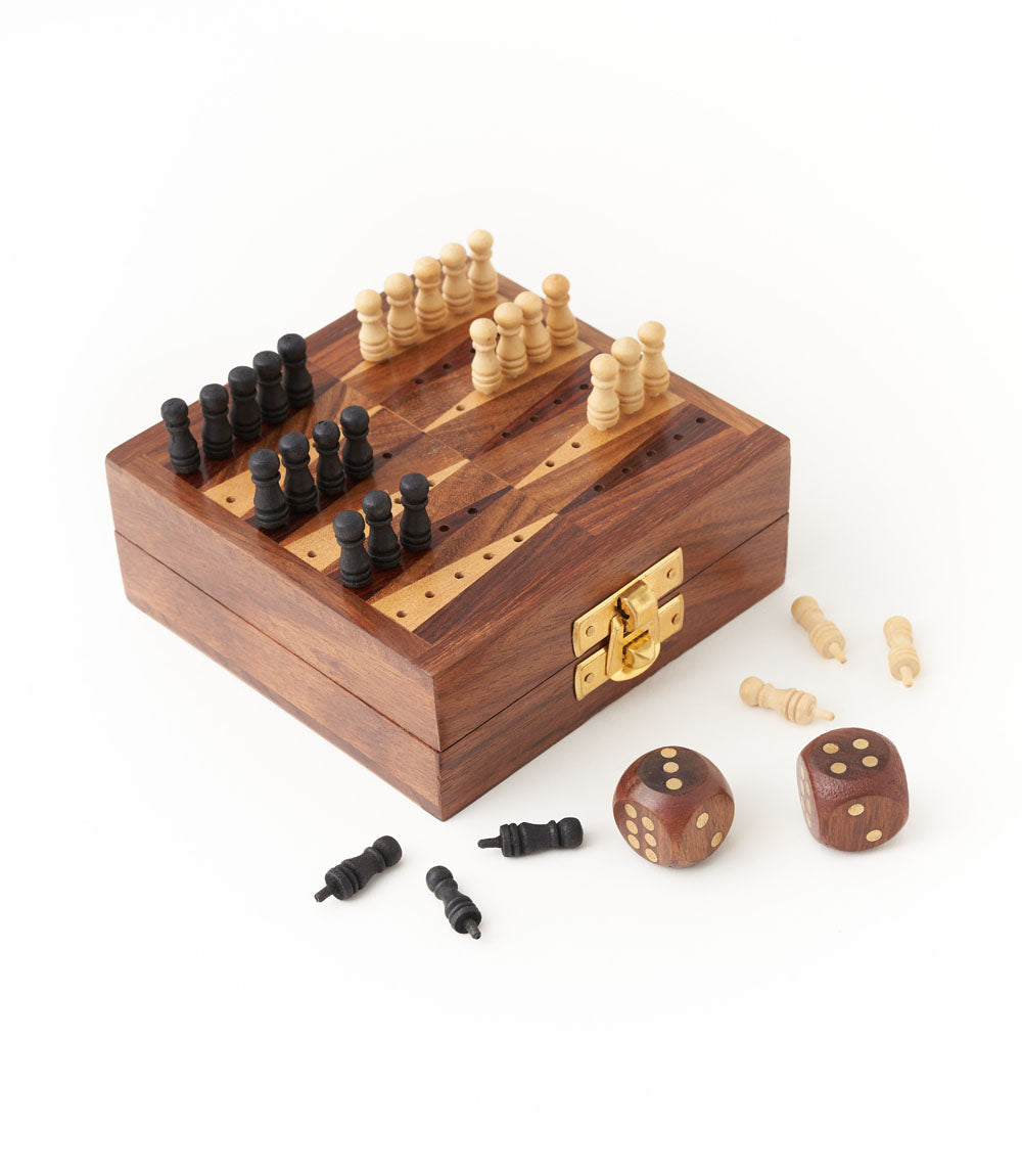 A wooden backgammon game set with black and white pegs arranged on the board and two dice with a white background.