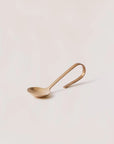 A serving spoon with a loop design for the handle displayed with a white background