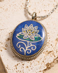 Necklace with a pendant featuring a lotus flower design on a textured stone surface