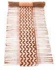 A decorative table runner featuring a geometric pattern with brown and white stripes, made from dried twigs and cotton cord
