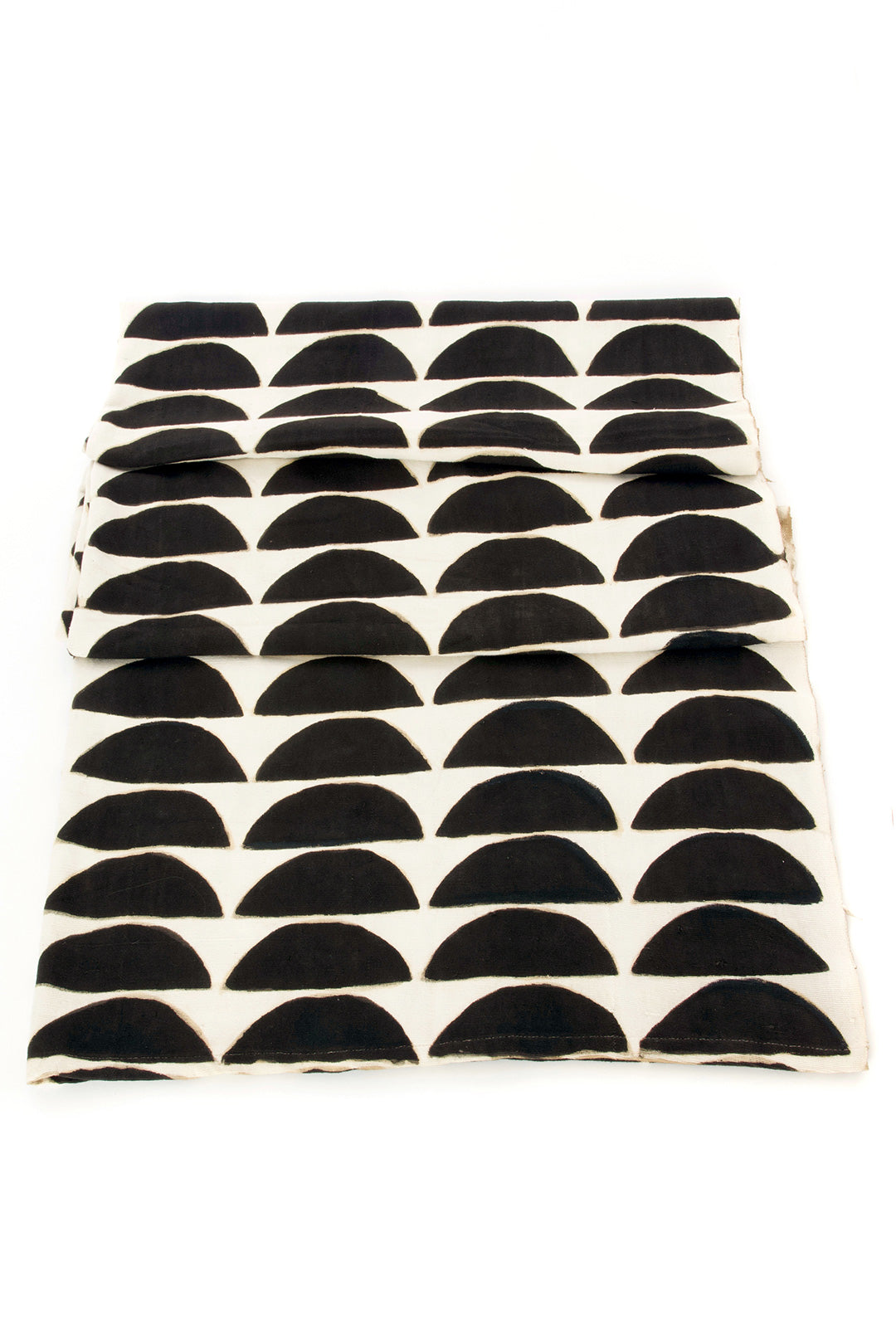 A natural cotton throw blanket that is carded, spun, woven and dyed by hand displayed against a white background