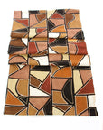 A folded organic cotton mudcloth throw with a geometric pattern in beige, brown, black, and white