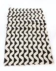A black and white geometric patterned mudcloth throw blanket laid out flat.