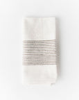 White cotton napkin with black stripes on a white background