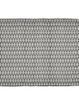 A striped placemat made of organic cotton, featuring a black and white pattern