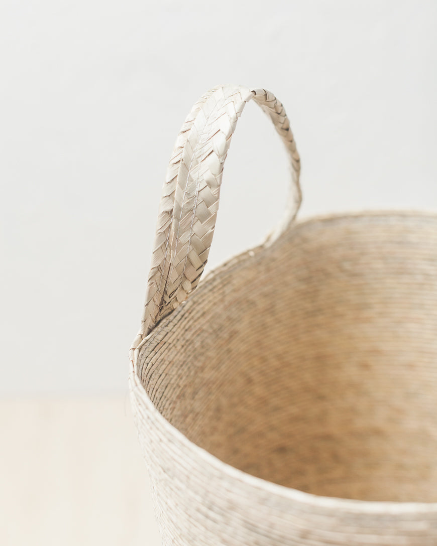 Close-up of a woven basket with a handle on a light background