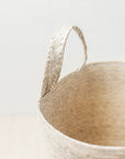 Close-up of a woven basket with a handle on a light background