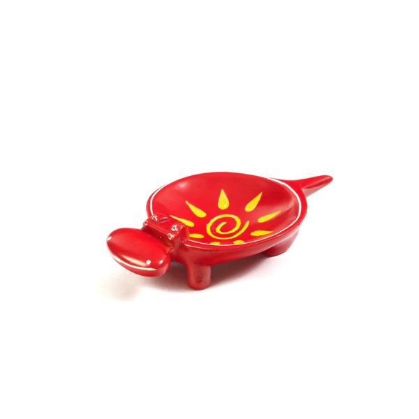 A small hand-carved red soapstone dish with a vibrant yellow and red sun design, crafted by artisans in Kenya