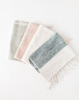 A set of three Riviera Cotton Hand Towels in different color combinations, featuring striped patterns and fringed edges