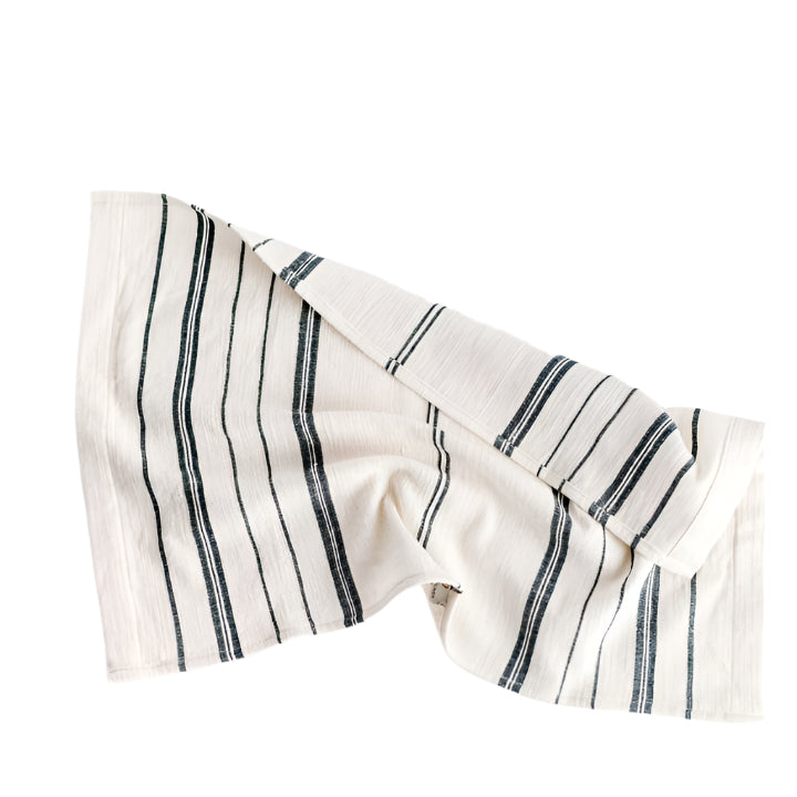 A white cotton tea towel with blue stripes and a visible hand-spun texture