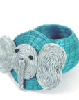 A handwoven turquoise elephant-shaped lidded basket made of sisal, intended for storing small items