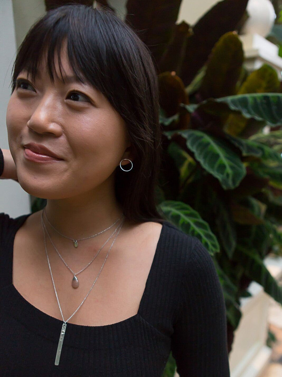 A model wearing a silver multi-strand multi-way pendant necklace with a pink chalcedony centerpiece stone