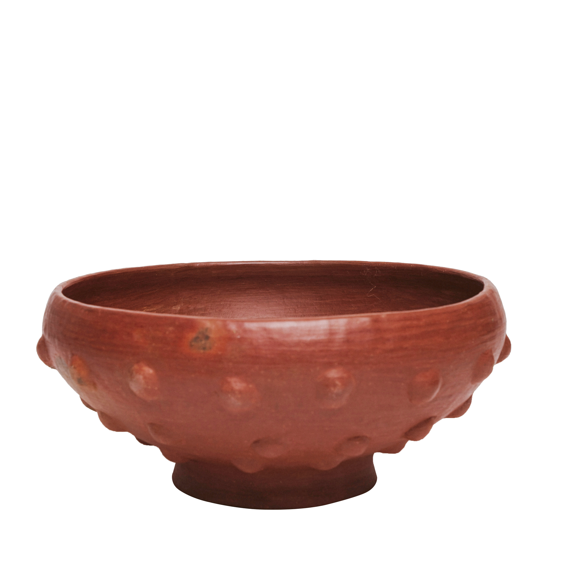 A handmade red clay decorative bowl with a textured exterior.
