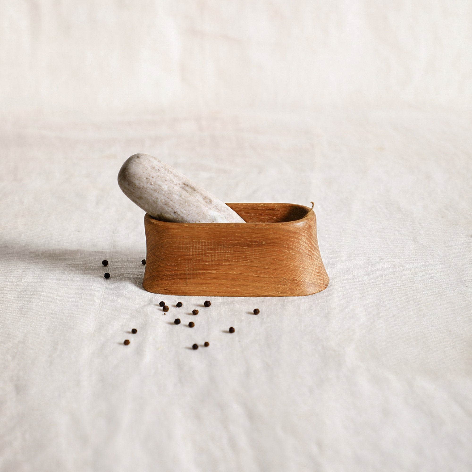 Oak and marble mortar and pestle set displayed on a countertop, blending natural materials with timeless design.