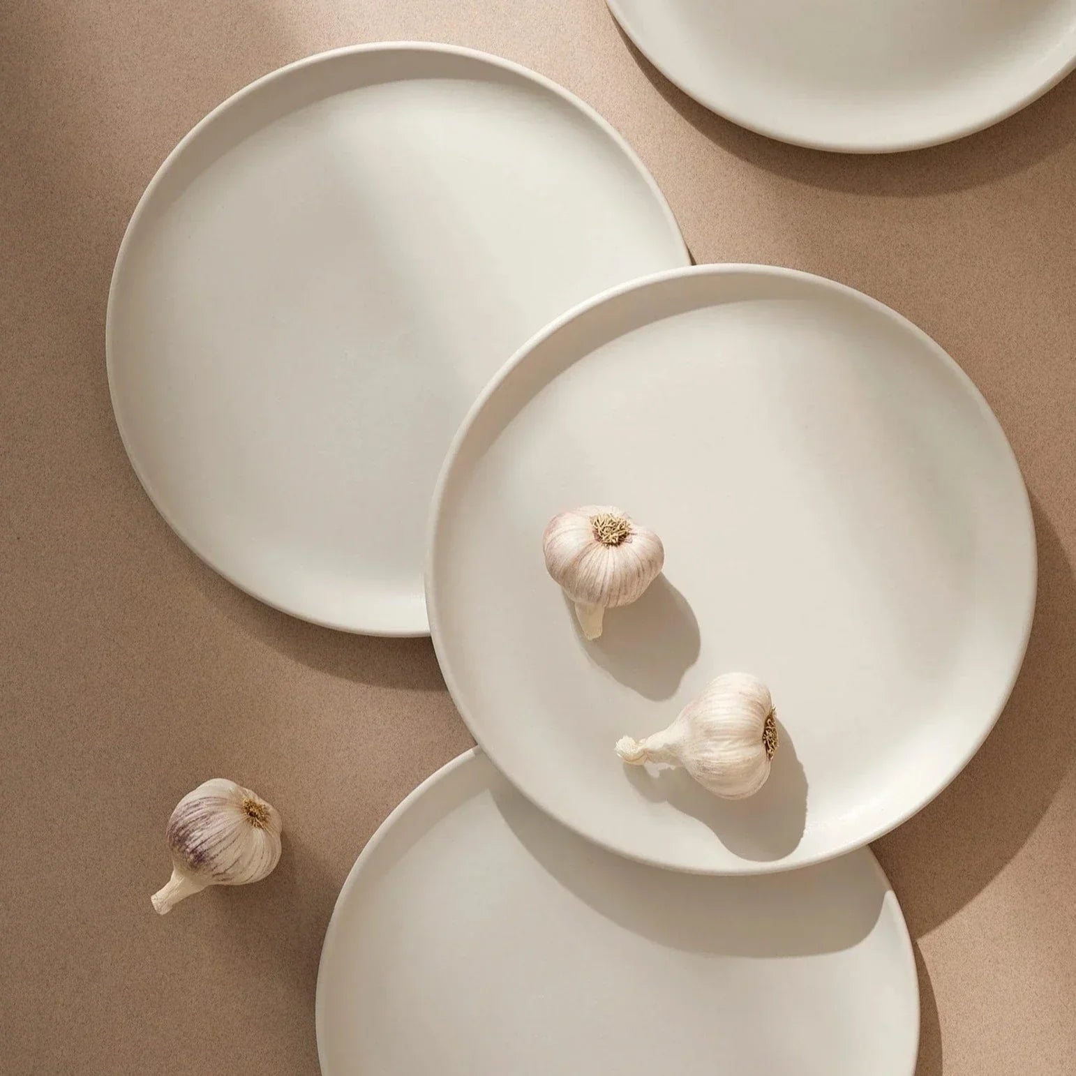 Set of four stoneware matte white dinner plates with cauliflower on top - plate collection at Better World Bio