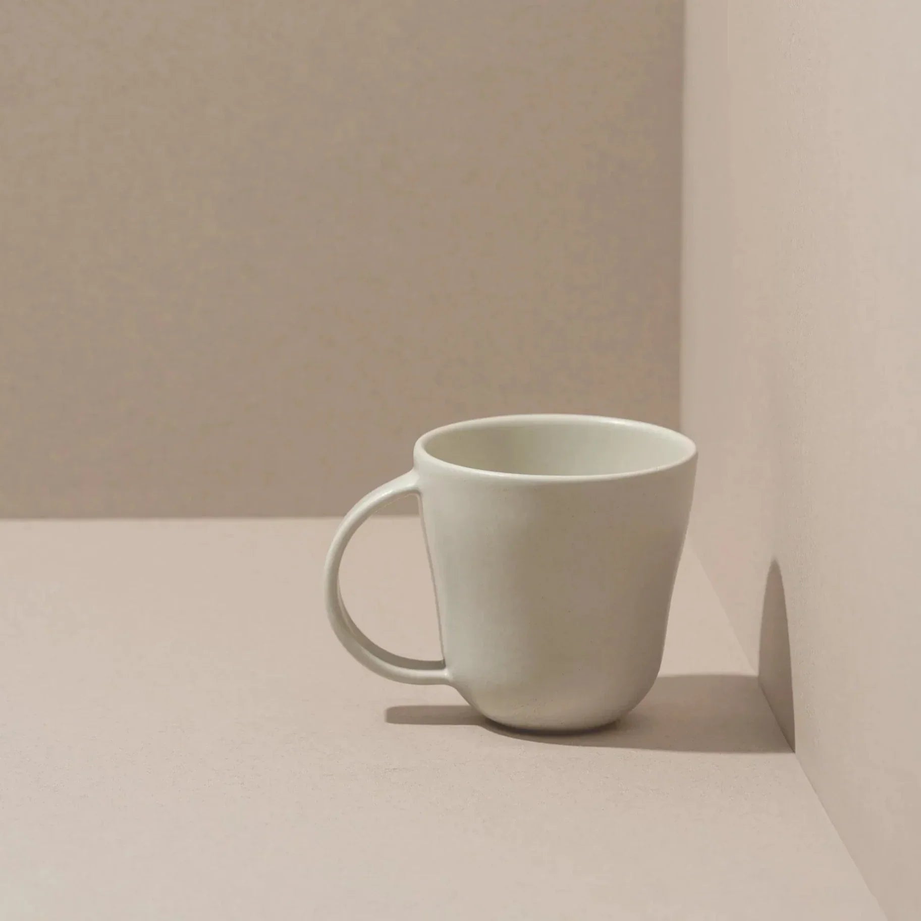 White glazed mug on a neutral colored background - mug collection at Better World Bio